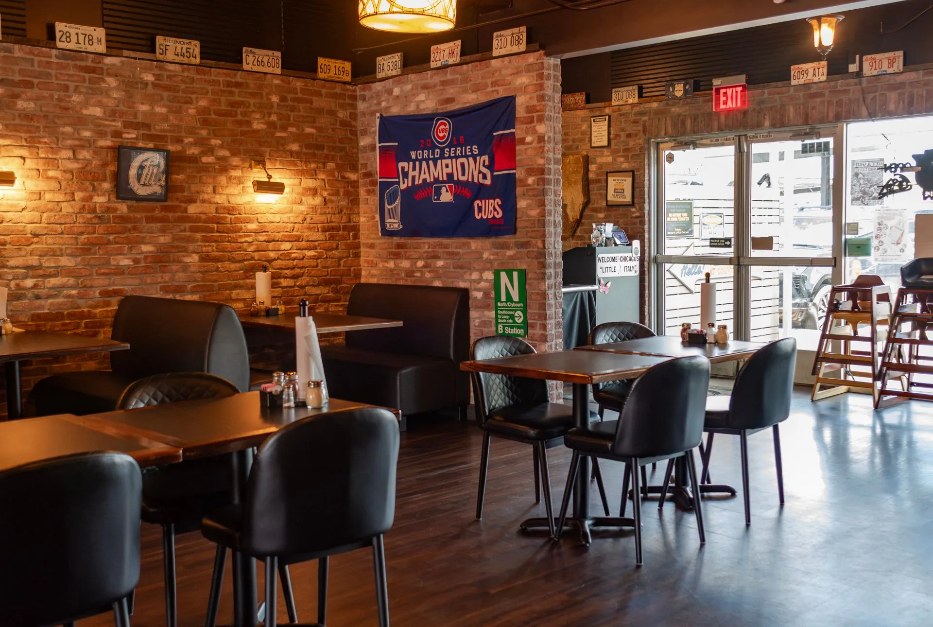 Tables by the front windows, with a Cubs World Series Champions banner on the brick wall